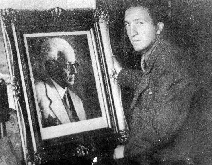 The photographer Mendel Grosman with a framed portrait photograph of Rumkowski.
